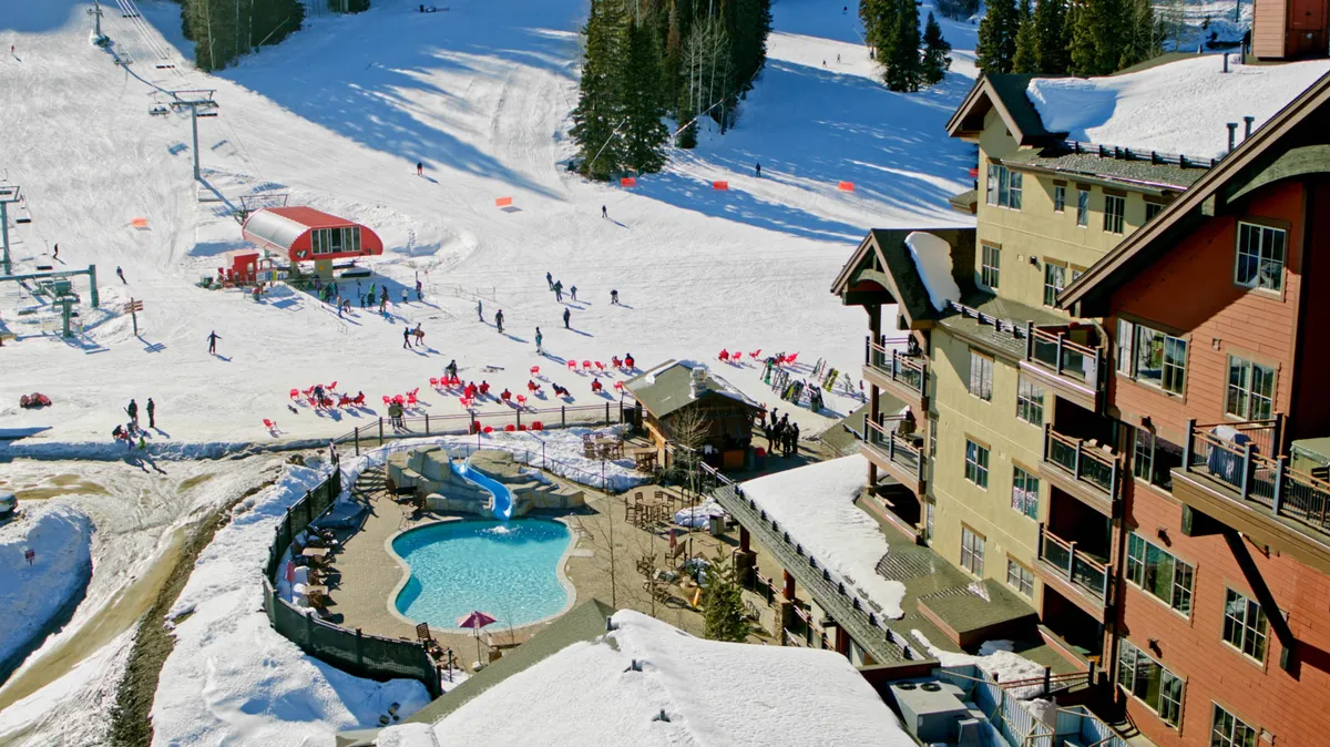 An exterior scene featuring lively ski slopes, an outdoor pool, a ski lift, lodge-style architecture, and people enjoying winter activities. The mood is active and festive, highlighting both resort access and après-ski relaxation.